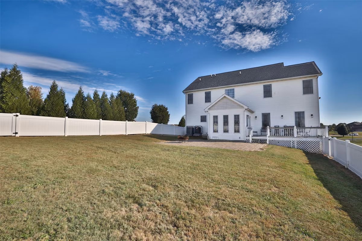 Rear exterior, deck, and fenced lawn