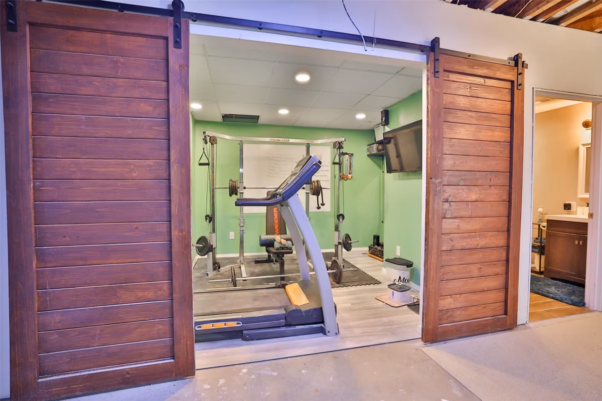 Exercise equipment behind sliding barn doors